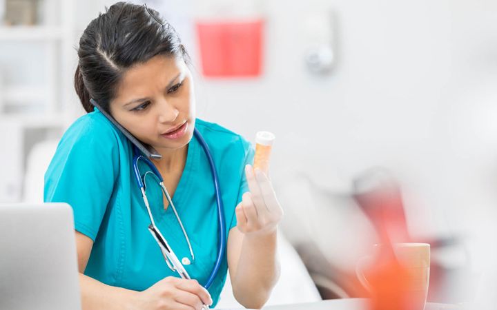 Nurse looking at prescription label - thumbnail image